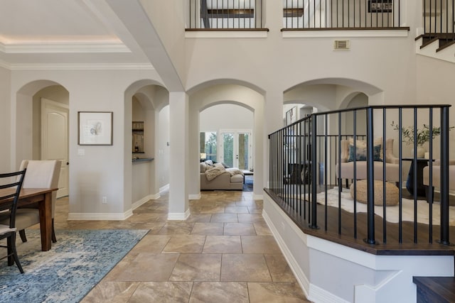 hallway featuring a high ceiling and crown molding