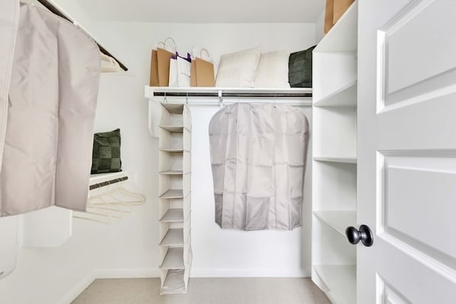 walk in closet featuring light carpet