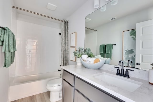 full bathroom with hardwood / wood-style flooring, shower / tub combo with curtain, vanity, and toilet