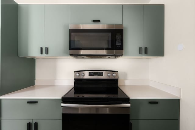 kitchen featuring green cabinets and range with electric stovetop