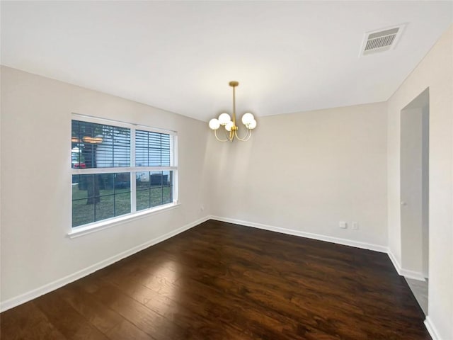 empty room with an inviting chandelier, baseboards, visible vents, and dark wood-style flooring