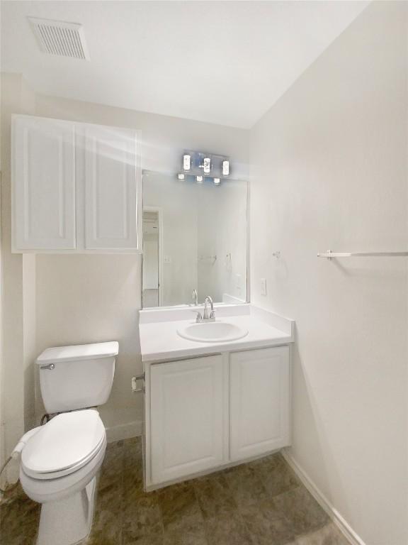 bathroom featuring toilet, baseboards, visible vents, and vanity