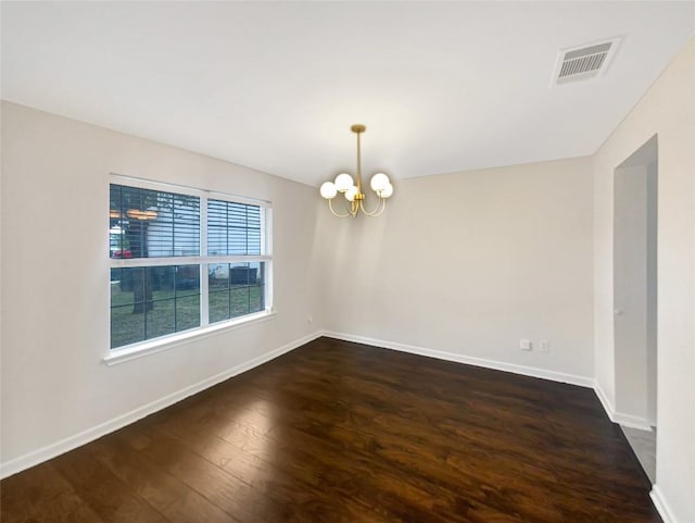 unfurnished room with baseboards, dark wood-type flooring, visible vents, and an inviting chandelier