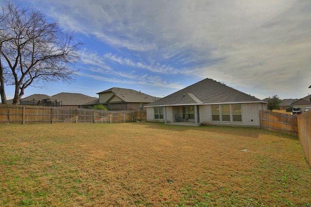 rear view of house featuring a yard and a patio