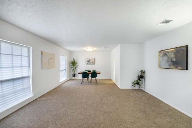 unfurnished room featuring light colored carpet and a textured ceiling