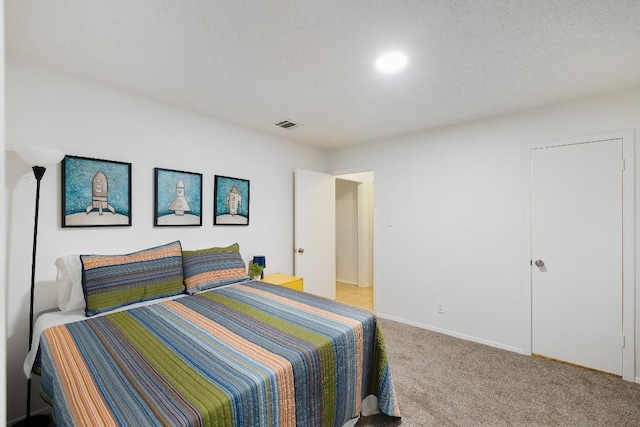 bedroom featuring light carpet and a textured ceiling