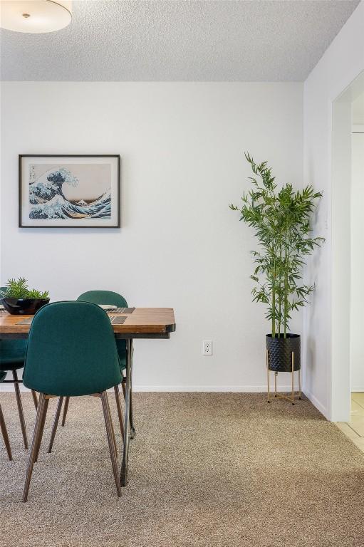 dining space with a textured ceiling and carpet