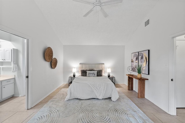 tiled bedroom featuring ceiling fan, ensuite bath, high vaulted ceiling, and a textured ceiling