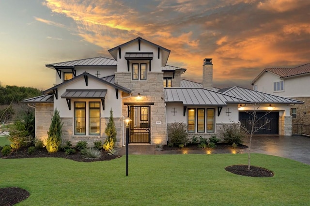 view of front of house featuring a garage and a lawn