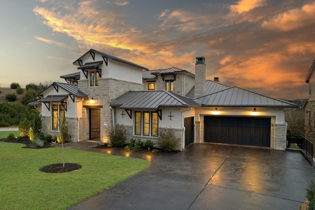 view of front of property with a garage and a yard