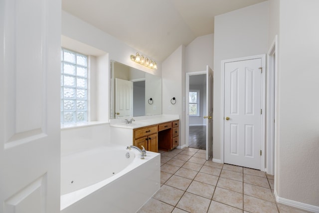 2901 Cashell Wood Dr, Cedar Park, TX 78613 - bathroom featuring vanity, a whirlpool tub, lofted ceiling, tile patterned flooring, and baseboards
