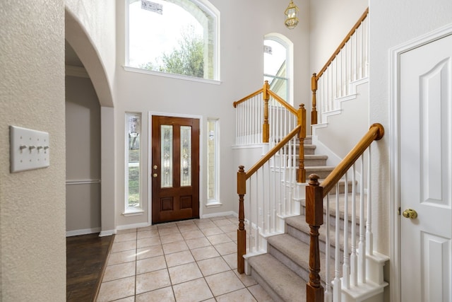 foyer entrance with light tile patterned floors and a high ceiling