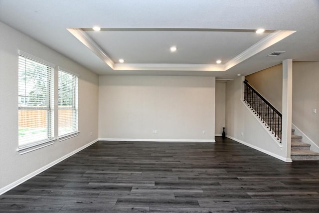 spare room with dark hardwood / wood-style floors, ornamental molding, and a tray ceiling