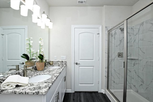 3 Pacific Loon St, Leander, TX 78641 - full bath featuring wood finished floors, double vanity, a shower stall, and a chandelier