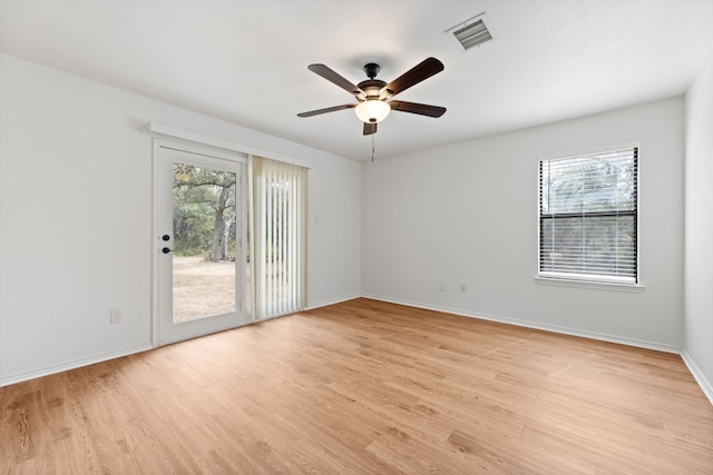 empty room with ceiling fan, light wood-style flooring, visible vents, and baseboards