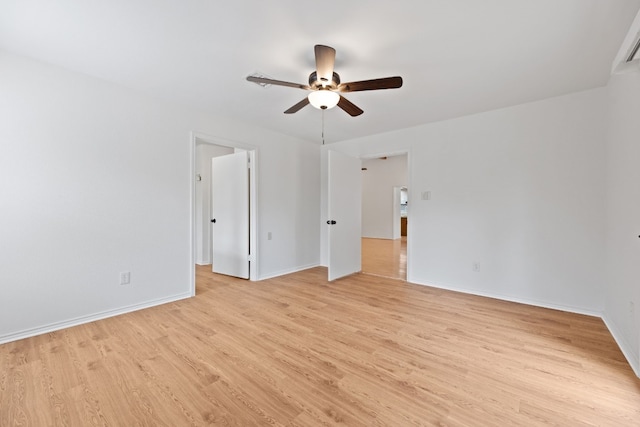 spare room featuring light wood-style floors, baseboards, and a ceiling fan