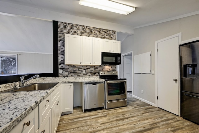 148 W Castleshoals Dr, Granite Shoals, TX 78654 - kitchen featuring tasteful backsplash, white cabinets, a sink, black appliances, and light wood finished floors