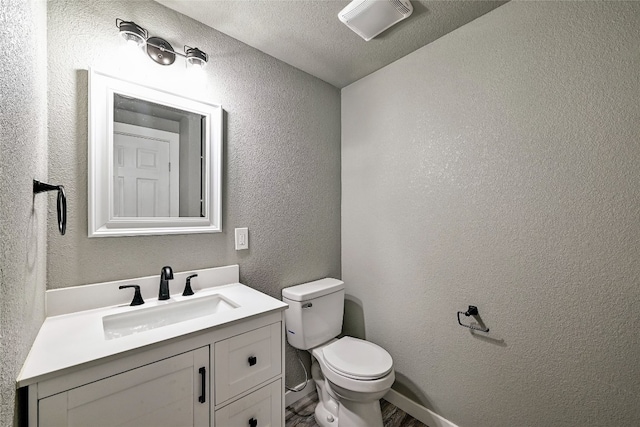 148 W Castleshoals Dr, Granite Shoals, TX 78654 - half bath with a textured ceiling, vanity, toilet, a textured wall, and baseboards