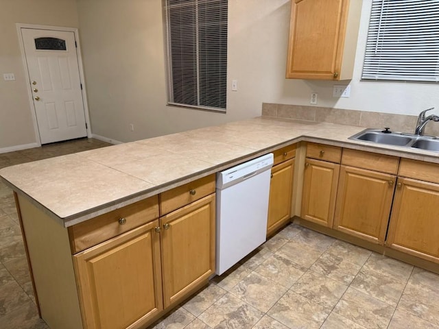 kitchen with sink, tile counters, kitchen peninsula, and dishwasher