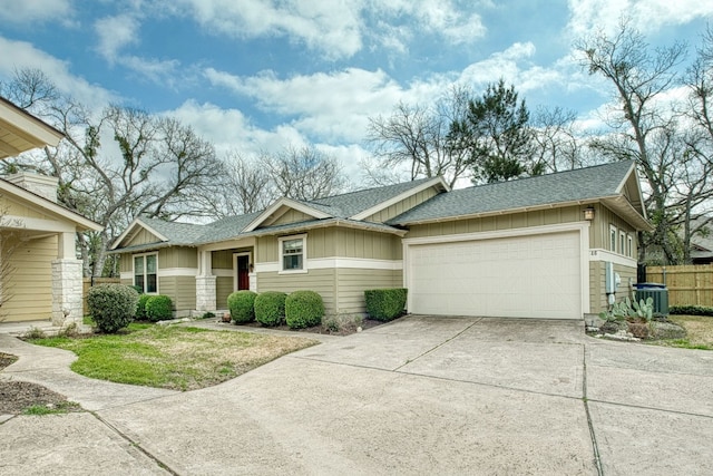 ranch-style home featuring a garage, cooling unit, and a front yard