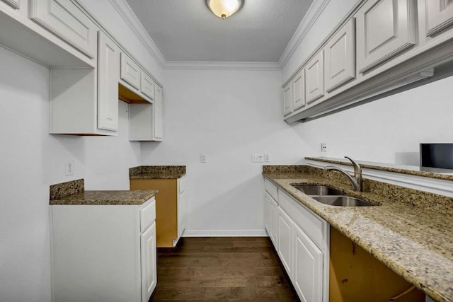 kitchen with sink, white cabinetry, ornamental molding, stone countertops, and dark hardwood / wood-style flooring