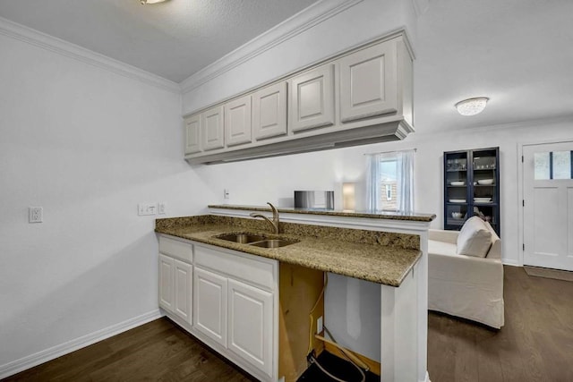 kitchen featuring white cabinetry, sink, and kitchen peninsula