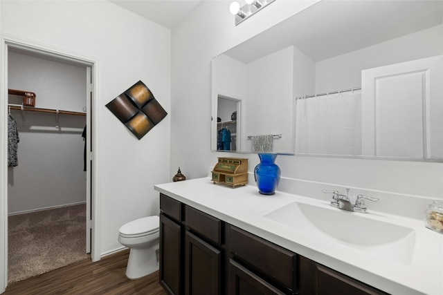 bathroom featuring vanity, hardwood / wood-style flooring, and toilet