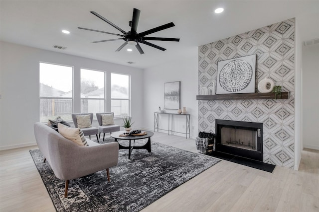 13701 Glen Mark Dr, Manor, TX 78653 - living area with wood finished floors, recessed lighting, ceiling fan, an accent wall, and a tiled fireplace