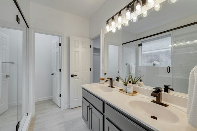 13701 Glen Mark Dr, Manor, TX 78653 - bathroom with a shower stall, double vanity, a closet, and wood finished floors
