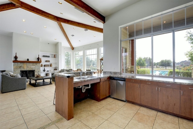 13701 Glen Mark Dr, Manor, TX 78653 - kitchen with dishwasher, a peninsula, a stone fireplace, and light tile patterned floors