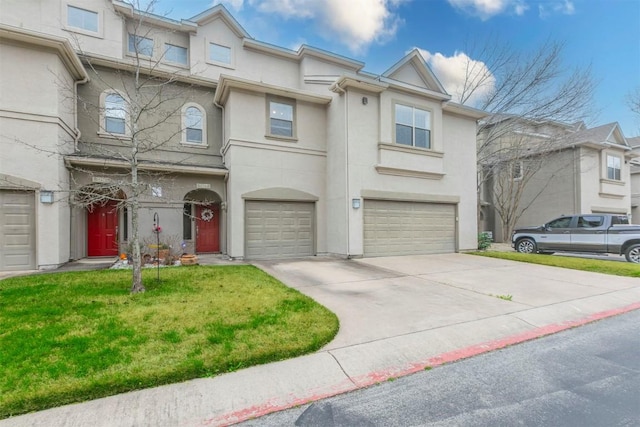 multi unit property featuring a garage and a front yard