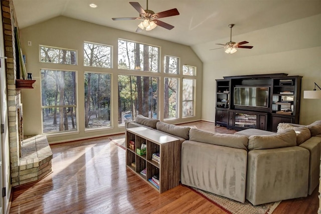 living room with lofted ceiling, light hardwood / wood-style floors, and ceiling fan