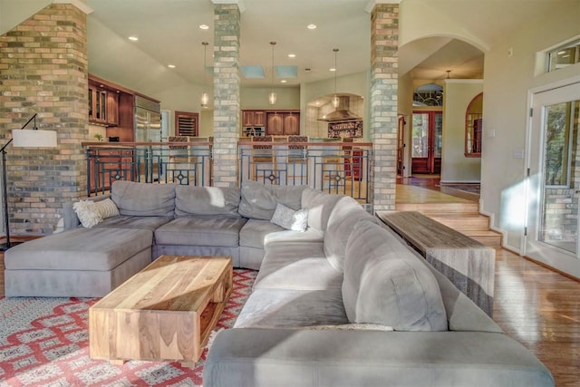 living room featuring ornate columns and light wood-type flooring