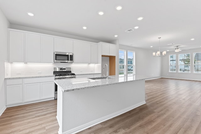 336 Blue Oasis Ln, Leander, TX 78641 - kitchen with a sink, appliances with stainless steel finishes, white cabinets, healthy amount of natural light, and recessed lighting