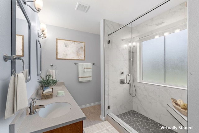 30388 Ledgemont Ln, Georgetown, TX 78628 - full bath featuring a sink, a stall shower, double vanity, visible vents, and baseboards