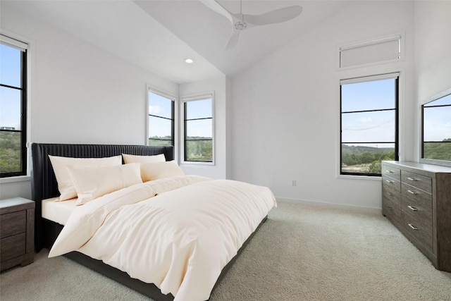 carpeted bedroom with ceiling fan, vaulted ceiling, and multiple windows