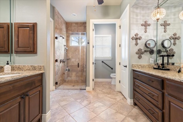 bathroom with vanity, a shower with shower door, and toilet