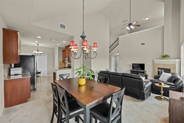 11000 Anderson Mill Rd Unit 100, Austin, TX 78750 - dining area featuring a chandelier, light carpet, baseboards, a tiled fireplace, and a high ceiling