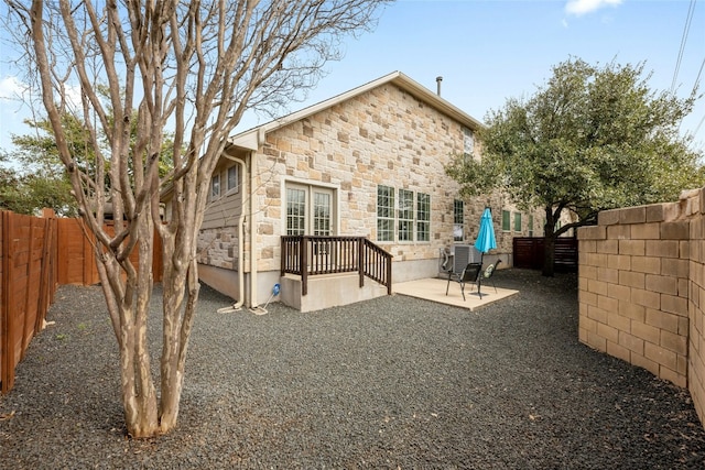 11000 Anderson Mill Rd Unit 100, Austin, TX 78750 - back of house with stone siding, a patio, and a fenced backyard