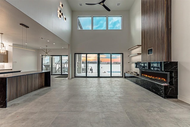 1012 Impala Dr, Granite Shoals, TX 78654 - unfurnished living room featuring a ceiling fan, a high ceiling, a wealth of natural light, and a fireplace