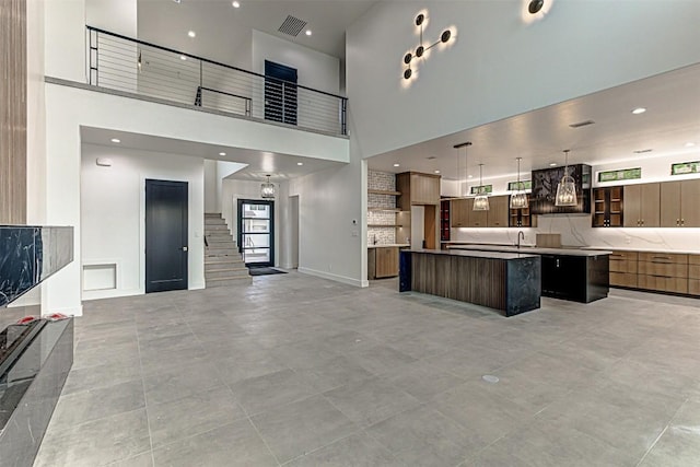 1012 Impala Dr, Granite Shoals, TX 78654 - kitchen with a large island, a towering ceiling, modern cabinets, a sink, and open floor plan