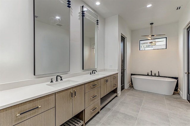 1012 Impala Dr, Granite Shoals, TX 78654 - bathroom featuring a sink, a freestanding bath, double vanity, and visible vents