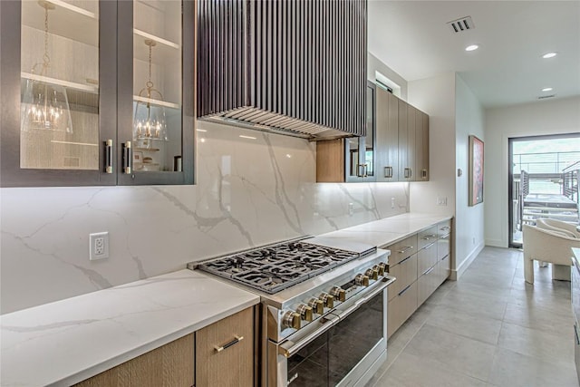 1012 Impala Dr, Granite Shoals, TX 78654 - kitchen with range with two ovens, wall chimney range hood, modern cabinets, decorative backsplash, and glass insert cabinets