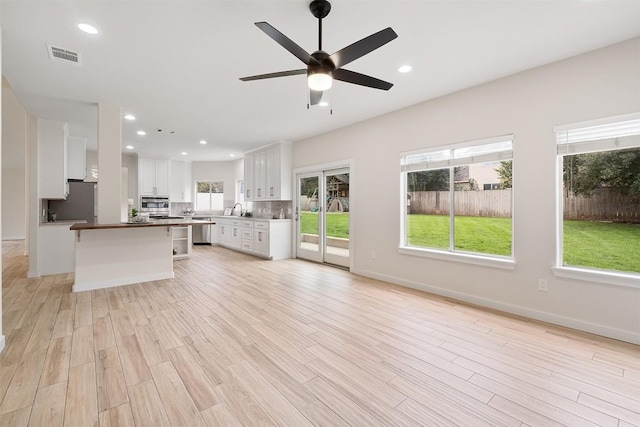 1302 Olympus Dr, Austin, TX 78733 - unfurnished living room with light wood finished floors, ceiling fan, recessed lighting, and baseboards