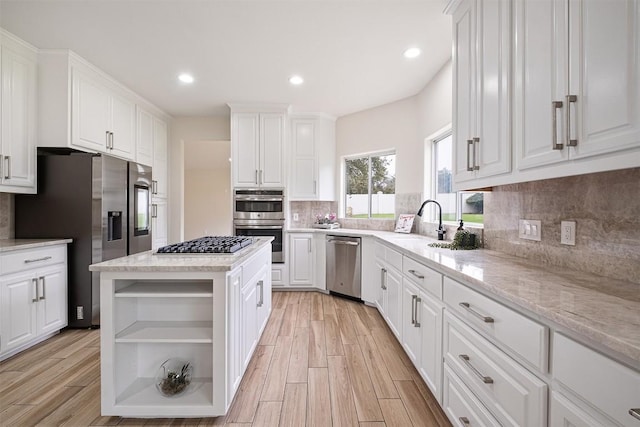 1302 Olympus Dr, Austin, TX 78733 - kitchen with appliances with stainless steel finishes, open shelves, white cabinets, tasteful backsplash, and light wood finished floors