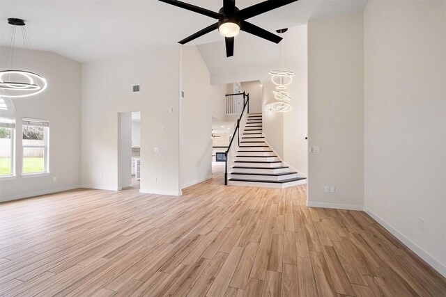 1302 Olympus Dr, Austin, TX 78733 - unfurnished living room featuring stairs, high vaulted ceiling, a ceiling fan, light wood-style flooring, and baseboards