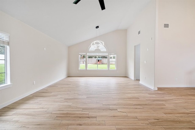 1302 Olympus Dr, Austin, TX 78733 - unfurnished living room featuring plenty of natural light, light wood-type flooring, a ceiling fan, baseboards, and high vaulted ceiling