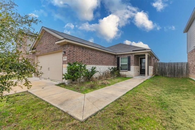 ranch-style home featuring a front lawn, fence, concrete driveway, an attached garage, and brick siding