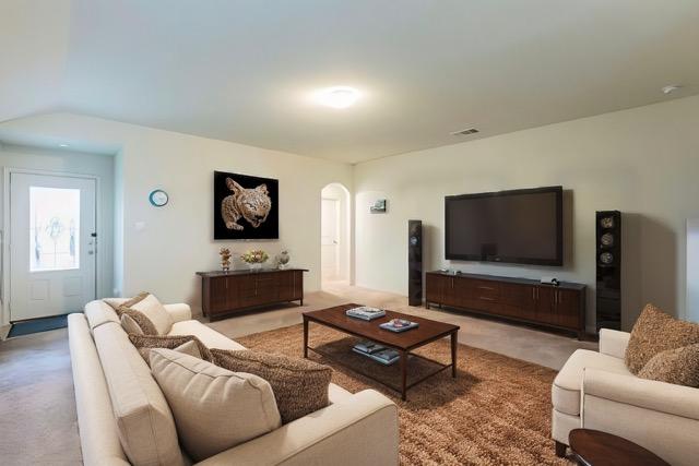 living area with visible vents, light colored carpet, and arched walkways