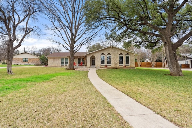 view of front of property featuring brick siding, a front yard, and fence